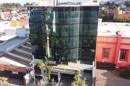 Dalco, empresa de construcción en México, muestra su moderno edificio con ventanales de vidrio.
